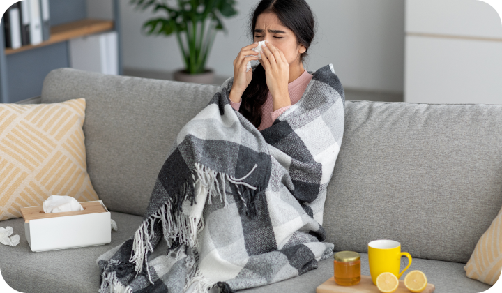 Frau mit Erkältung auf Sofa